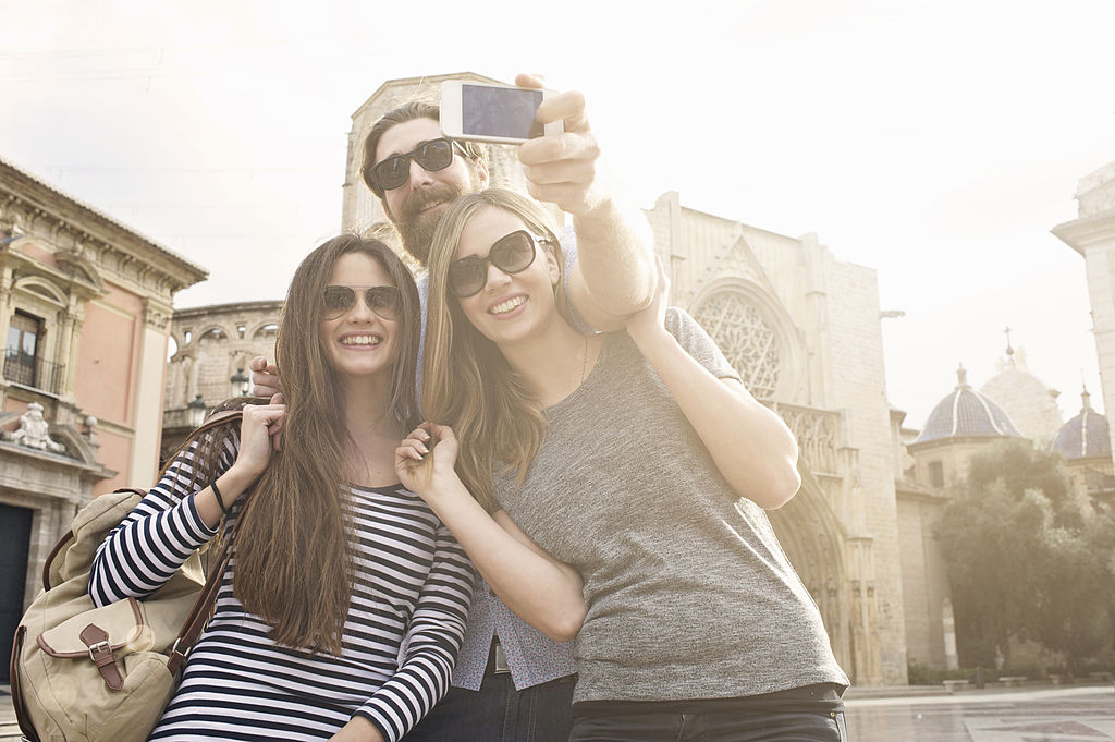 Three tourists taking self portrait, Plaza de la Virgen, Valencia, Spain