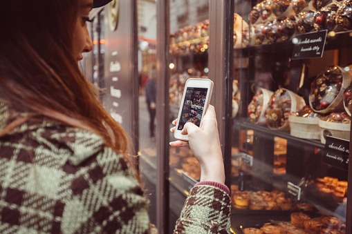 Woman photographing the candy shop window